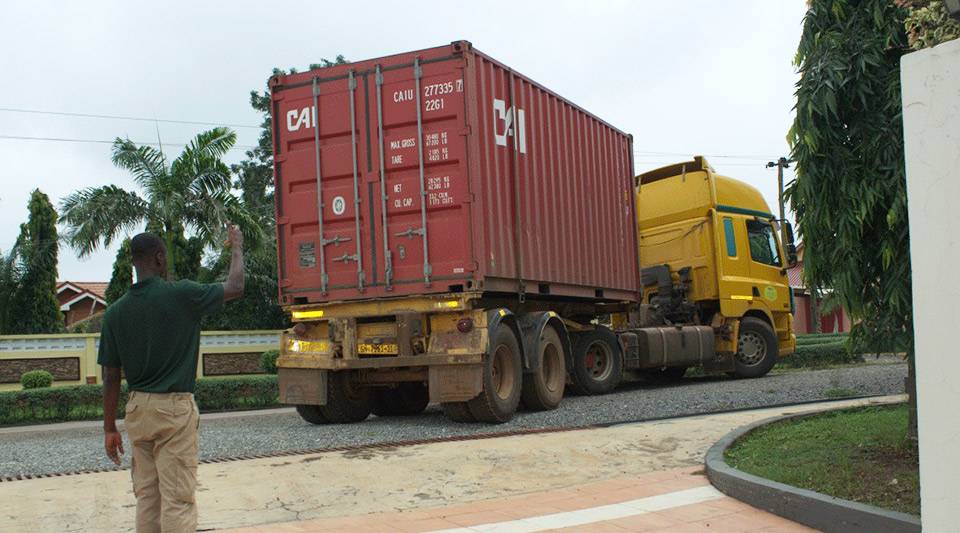 A lorry delivery of a shipping container filled with packaged boxes